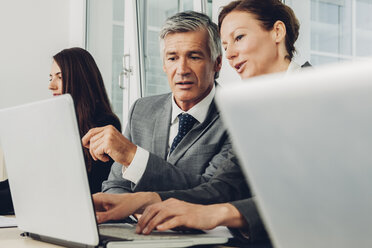 Business people sitting in office listening to presentation - CHAF000477