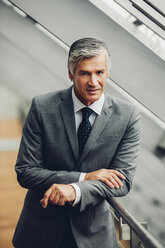 Mature businessman standing by railing - CHAF000489