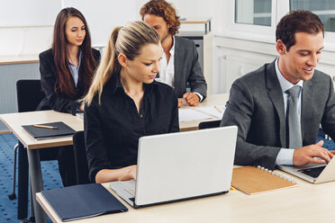 Geschäftsleute im Büro arbeiten am Laptop - CHAF001318