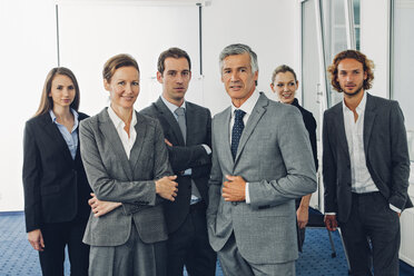 Eine Gruppe von Geschäftsleuten steht in einem Büro und schaut in die Kamera - CHAF000514
