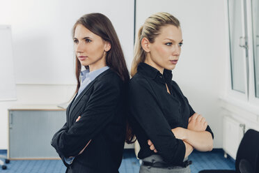 Zwei junge Geschäftsfrauen stehen Rücken an Rücken - CHAF000521