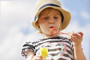 Portrait of little girl trying to blow soap bubbles - STKF001333