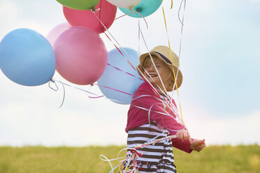 Kleines Mädchen mit Luftballons auf einer Wiese - STKF001349