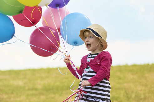 Kleines Mädchen mit Luftballons auf einer Wiese - STKF001350