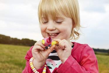 Portrait of happy little girl with party blowout - STKF001359