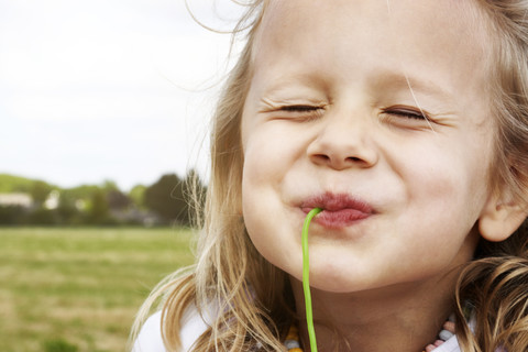 Portrait of happy little girl eating sweets stock photo