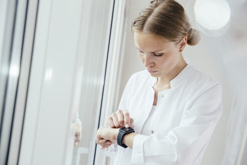 Ärztin schaut auf ihre Smartwatch - MFF001838
