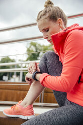 Young sporty woman checking her smart watch - MFF001858