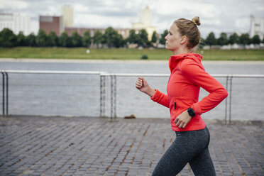 Deutschland, Köln, junge Frau beim Joggen am Rhein - MFF001859