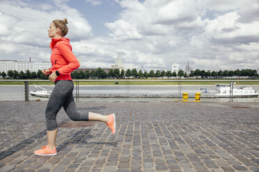 Deutschland, Köln, junge Frau beim Joggen am Rhein - MFF001862