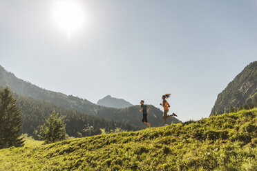 Österreich, Tirol, Tannheimer Tal, junges Paar joggt in alpiner Landschaft - UUF004921