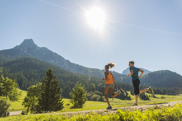 Österreich, Tirol, Tannheimer Tal, junges Paar joggt in alpiner Landschaft - UUF004923
