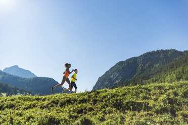 Österreich, Tirol, Tannheimer Tal, junges Paar joggt in alpiner Landschaft - UUF004927