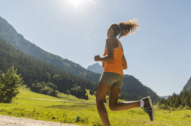 Österreich, Tirol, Tannheimer Tal, junge Frau joggt in alpiner Landschaft - UUF004928