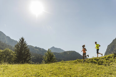 Österreich, Tirol, Tannheimer Tal, junges Paar joggt in alpiner Landschaft - UUF004929