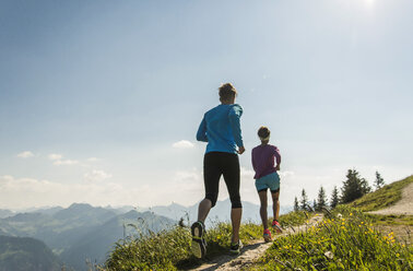 Österreich, Tirol, Tannheimer Tal, junges Paar joggt in den Bergen - UUF004970