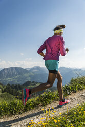 Österreich, Tirol, Tannheimer Tal, junge Frau joggt in den Bergen - UUF004971