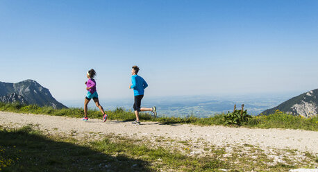 Österreich, Tirol, Tannheimer Tal, junges Paar joggt in den Bergen - UUF004972