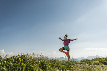 Austria, Tyrol, Tannheim Valley, young woman exercising in mountains - UUF004977
