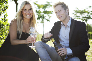 Elegant young couple outdoors drinking wine - GDF000803