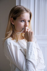 Blond young woman with pearl necklace thinking - CHAF000561