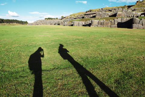 Peru, Cusco, shadow of two backpackers visiting Saksaywaman citadel stock photo