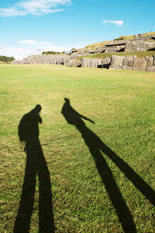 Peru, Cusco, Schatten von zwei Rucksacktouristen bei der Besichtigung der Zitadelle von Saksaywaman - GEMF000283