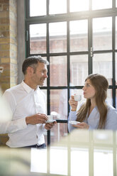 Mature man and young woman having a coffee break - FKF001380