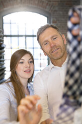 Junge Frau hilft einem Kunden bei der Auswahl einer Krawatte - FKF001386