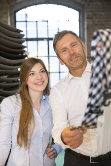 Junge Frau hilft einem Kunden bei der Auswahl einer Krawatte - FKF001387