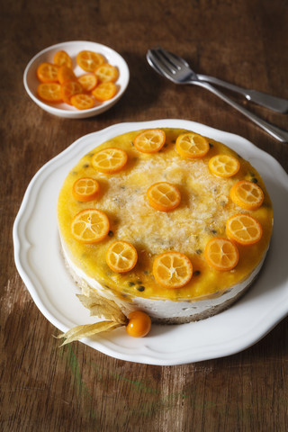 Mango-Passionsfrucht-Torte, dekoriert mit Kumquat-Scheiben, lizenzfreies Stockfoto