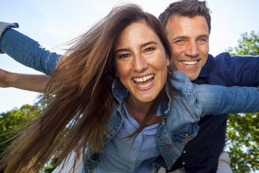 Happy couple in park pretending to fly - CHAF000756