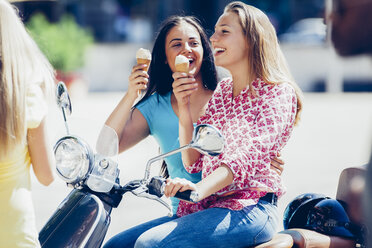 Two teenage girls with motor scooter and ice cream cones - CHAF000787