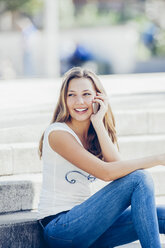 Porträt eines lächelnden Teenagers, der mit einem Smartphone telefoniert - CHAF000788