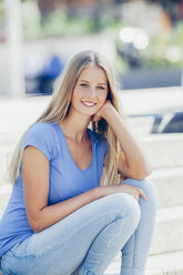 Portrait of smiling teenage girl with head in her hand - CHAF000795