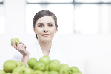 Portrait of smiling young woman with apple - ZEF006387