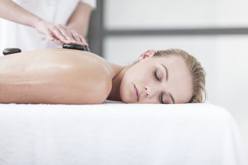 Frau erhält Hot-Stone-Massage in einem Spa - ZEF006398