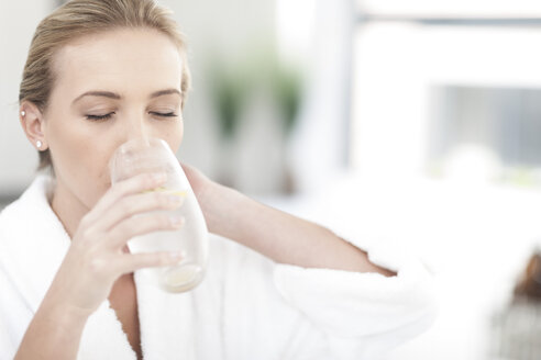 Woman drinking glass of water in a spa - ZEF006413