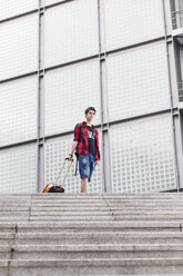 Germany, Berlin, teenage boy with rolling suitcase - MMFF000858