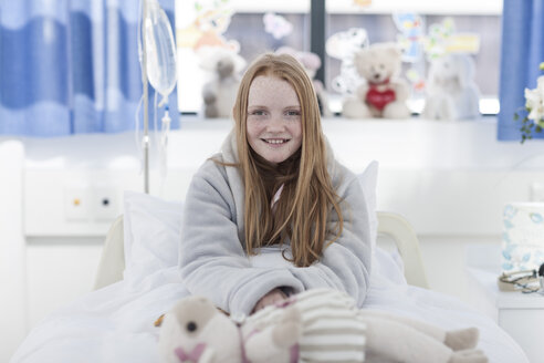 Porträt eines lächelnden Mädchens mit roten Haaren im Krankenhausbett - ZEF006009