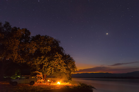 Simbabwe, Bezirk Urungwe, Mana-Pools-Nationalpark, Lagerfeuer am Flussufer des Sambesi bei Nacht, lizenzfreies Stockfoto