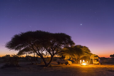 Botswana, Kalahari, Central Kalahari Game Reserve, campsite with campfire under starry sky - FOF008271