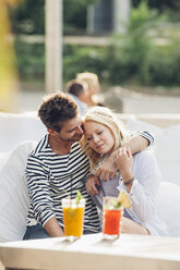 Young couple sitting together in an outdoor lounge - CHAF000812