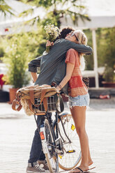 Junges Paar mit Fahrrad, das sich auf der Straße umarmt - CHAF000823