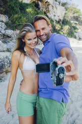 Pärchen, das sich am Strand mit einem Camcorder filmt - CHAF000676