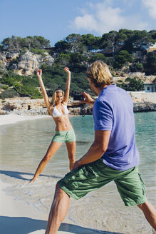 Spanien, Mallorca, Frau am Strand posiert für Mann mit Kamera - CHAF000681