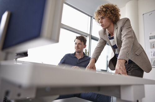 Zwei Kollegen im Büro schauen auf den Computerbildschirm - RHF000908