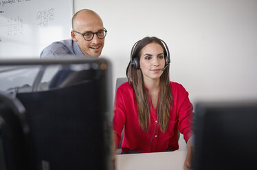 Mann und Frau mit Headset im Büro - RHF000909