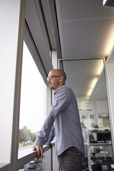 Man in office looking out of window - RHF000925