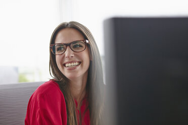 Smiling young woman with glasses in office - RHF000943